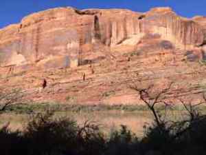 Red rock wall against the Colorado (red) River.